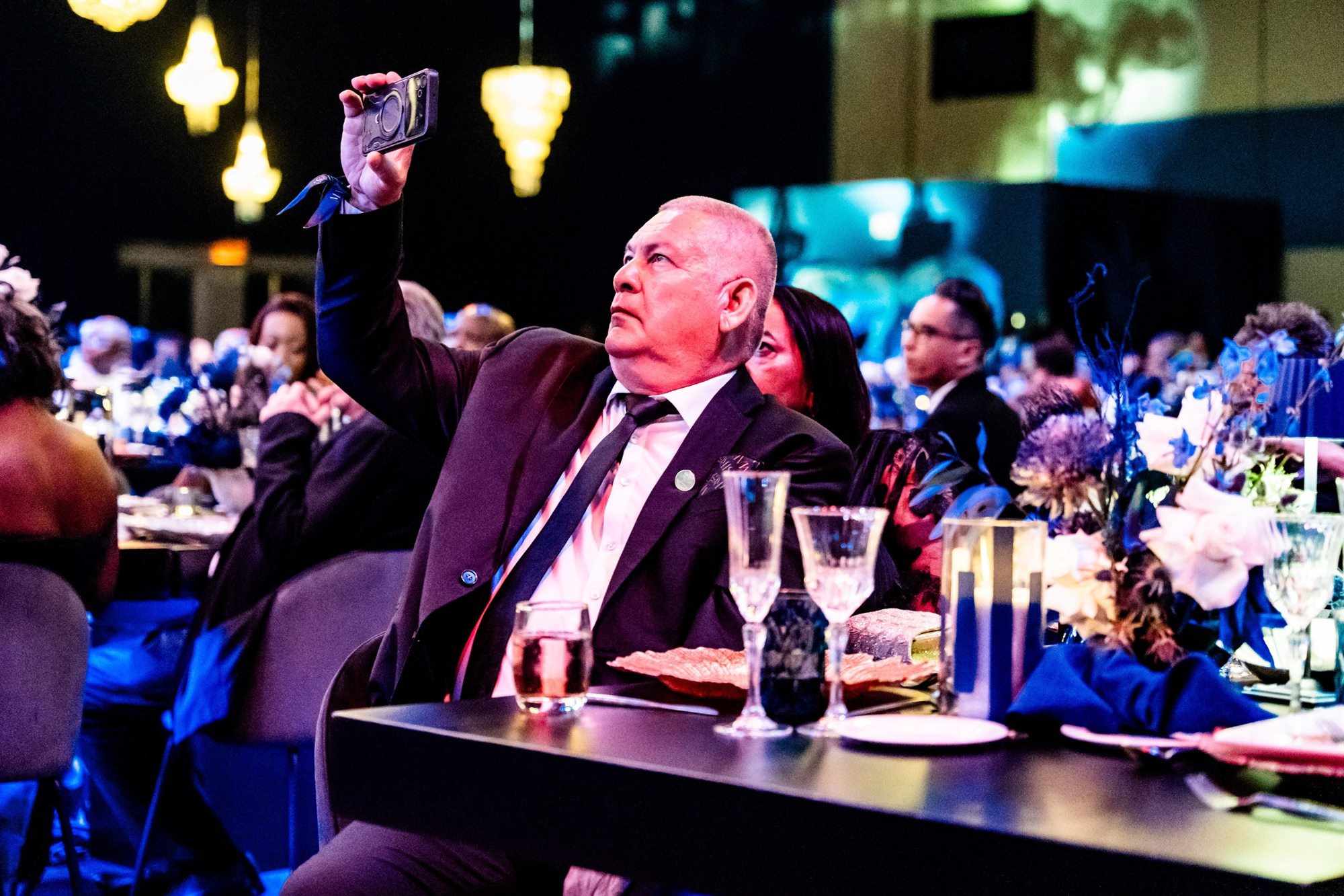 Guest raising a phone to film during a gala dinner