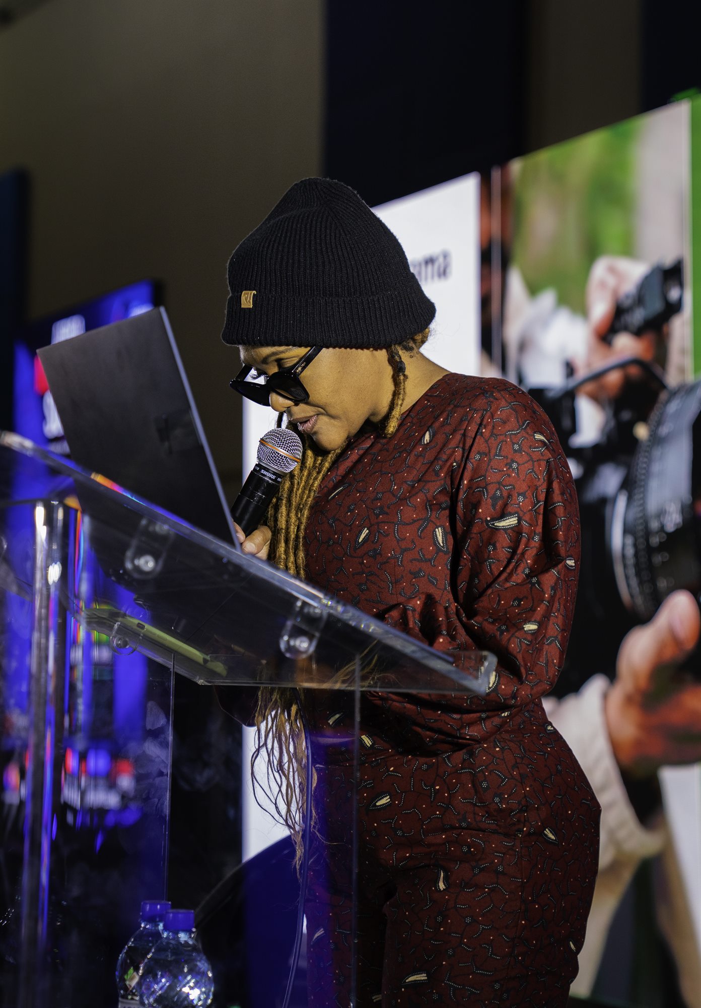 Speaker reading from a lectern at a branded event