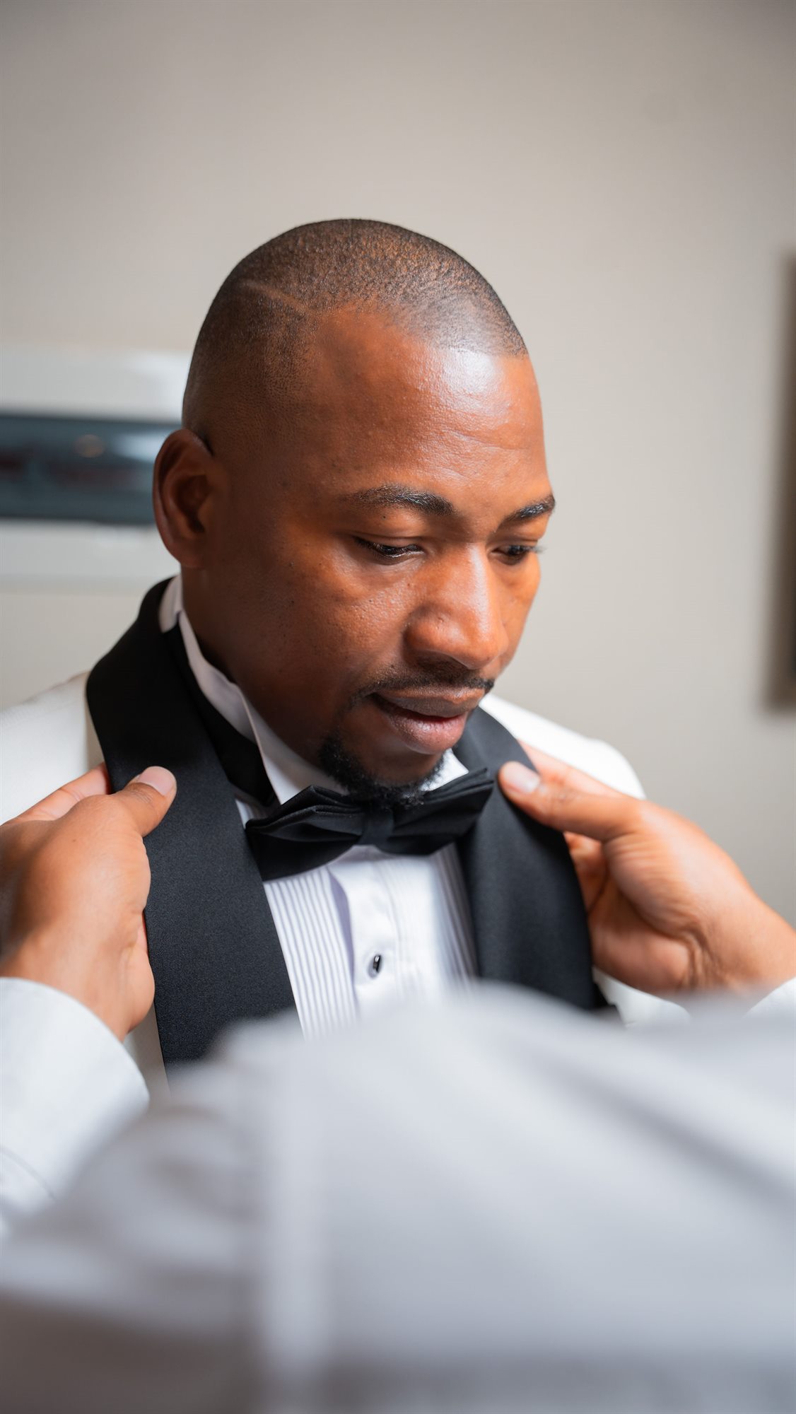 Groom having his bow tie adjusted before the ceremony