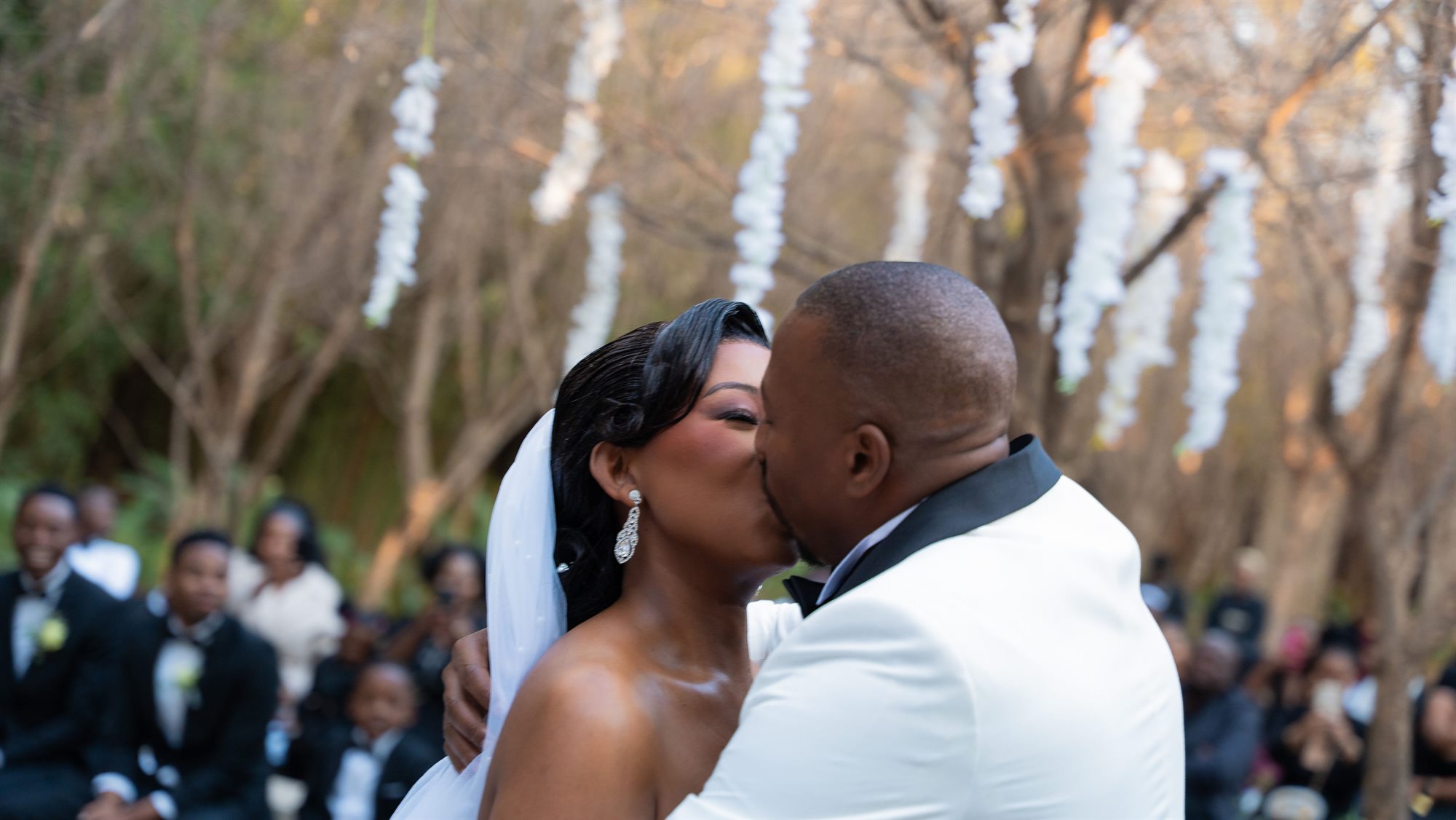 Bride and groom kissing at the altar in front of their guests